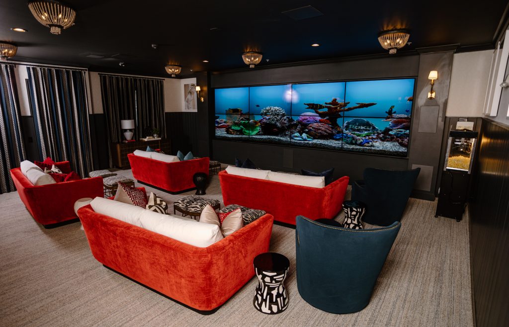 Luxe 88 Screening room with couches, chairs, and an 8 screen theater wall