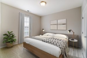 Kendall Park H Unit bedroom, bed in forefront with small nightstand and wall art behind bed