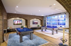 Taylor House Clubhouse billiards tables with mounted televisions in tufted cutout seating areas