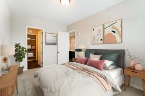 Unit B Bedroom with bed in forefront and view to bathroom and walk in closet